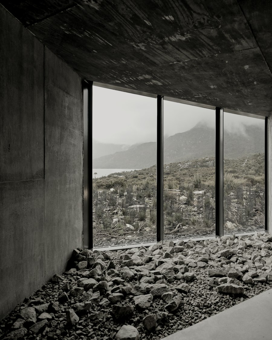 The garden room of Kitayama House: a gravel floor, concrete walls and tall windows onto a wooded valley.